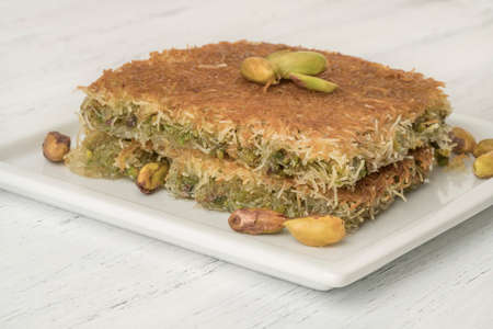 closeup traditional Turkish dessert kadayif with pistachio on a wooden tableの写真素材