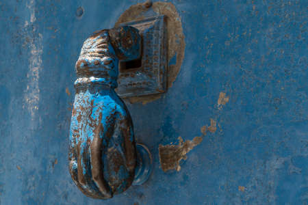 closeup hand shaped door knock on an old and rusty blue door in Anatolia, Turkeyの写真素材