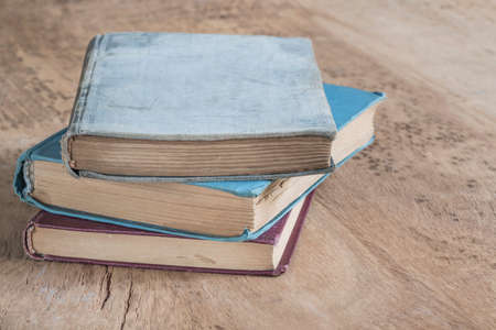 stack of old books on a wooden table with copy spaceの写真素材