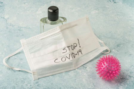 cologne and white disposable surgical mask against covid-19 corona virus on blue with copy space
