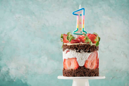 a strawberry cake with number one shaped candle for birthdayの写真素材