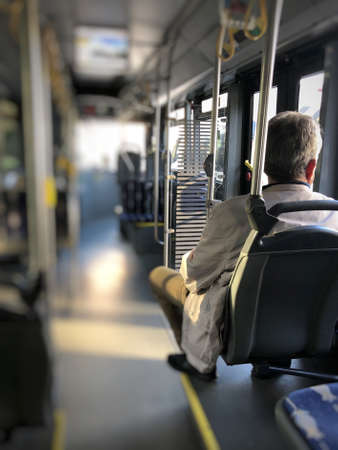 blurred background with a man sitting in an empty public busの写真素材