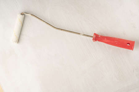 closeup of a paint roller for whitewashing on a surface with copy spaceの写真素材