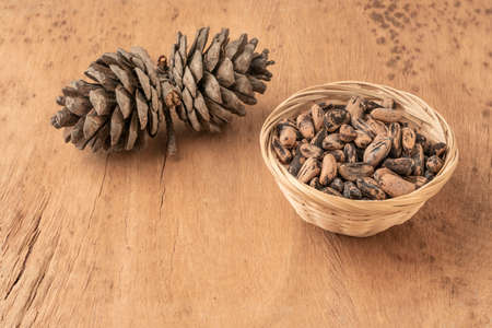 natural pine nuts, kernels and cone on a wooden tableの写真素材