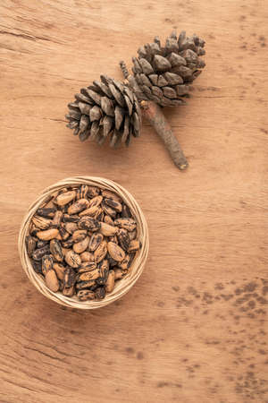 natural pine nuts, kernels and cone on a wooden tableの写真素材