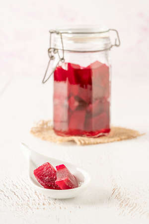 Natural probiotic homemade pickled beetroots in a jar on a wooden table with copy spaceの写真素材