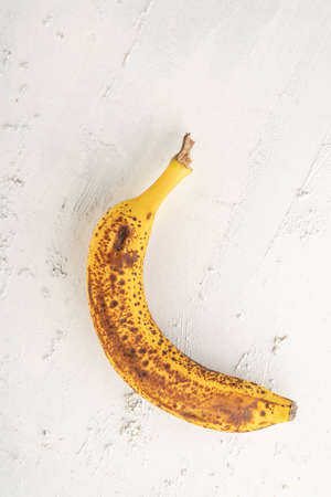 a ripe banana on a white textured background with copy spaceの写真素材