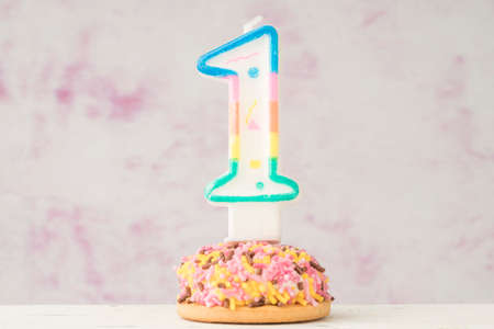 a small colorful cupcake with number one shaped candle for birthday celebrationの写真素材