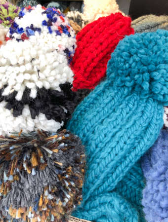 closeup colorful pompoms of knitted hats as a background