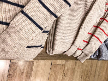 closeup folded wool jumpers on a self in storeの写真素材