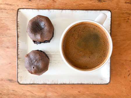 cup of coffee and small chocolate cakes on the table