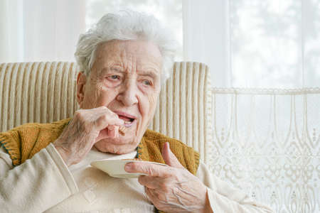 a senior woman woman eating something at home