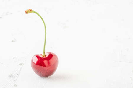 closeup of a ripe cherry fruit on white with copy spaceの写真素材