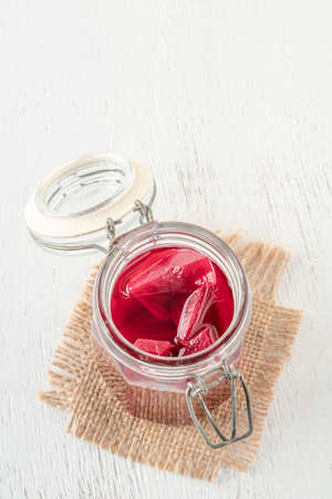 Natural probiotic homemade pickled beetroots in a jar on a wooden table with copy spaceの写真素材