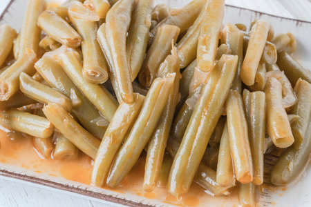 closeup fresh green bean cooked with olive oil on plate on table