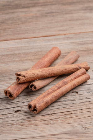 some dried cinnamon sticks on a wooden table with copy space