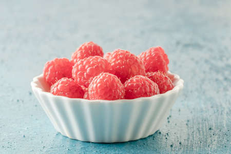 closeup ripe fresh raspberry fruits in a bowl on table with copy spaceの写真素材