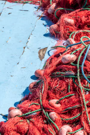 pile of red fishing nets on wooden background of a boat with copy spaceの写真素材