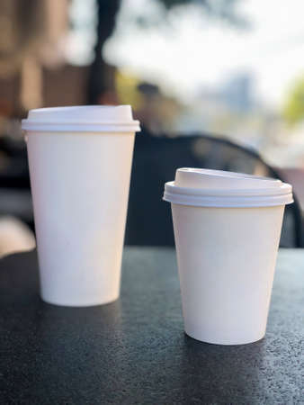 two take away coffee mugs on the table in a cafe with copy space. selective focusの写真素材
