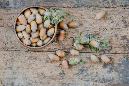 hazelnuts with nutshells in a bowl on a wooden table