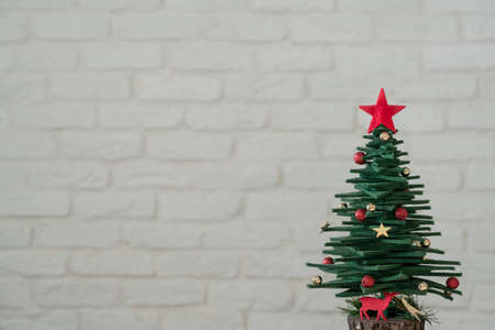 New year, Christmas greeting background with pine tree shaped ornaments over white brick wall with copy space. new year card, Christmas or christmas ornaments.の写真素材