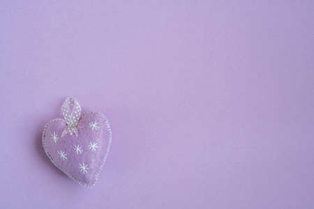 blank greeting card template with one fabric heart on purple background or surface for valentines or mothers day.の写真素材