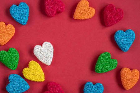 candy, top view of colorful heart shaped jelly candy sweets isolated on red background for valentines day. sweet food concept background or surface with heart shaped jelly sugars with copy spaceの写真素材