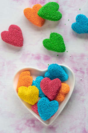candies, top view of colorful jelly candy sweets in a heart shaped plate for valentines day. sweet food concept background or surface with multicolored heart shaped jelly sugars on tableの写真素材