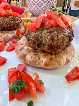 meatballs, closeup side view delicious meatballs served on pita bread with tomato salad on plate for...