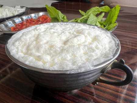 Buttermilk, Traditional yoghurt drink or beverage known as ayran in Turkish with foam in silver...