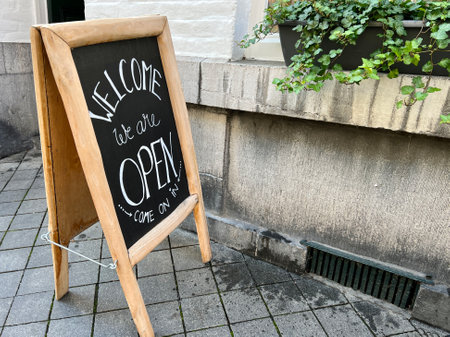 sign board in front of a shop or cafe door. chalk board with open sign at street, entrance of a shop...