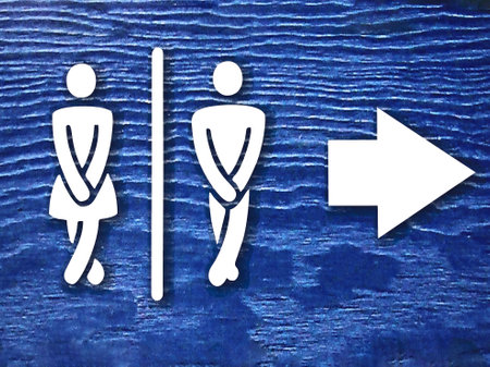 public toilet sign board with white woman and man figure and arrow on blue background or surface. public toilet or wc sign board photo with copy spaceの写真素材