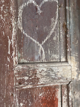 door, white heart shape on old wooden door or background. blank or empty heart shape on wooden background or surface with copy spaceの写真素材