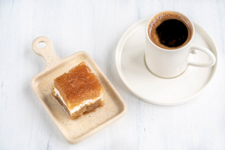coffee and dessert, cup of coffee and traditional turkish baked syrup dessert known as revani in...