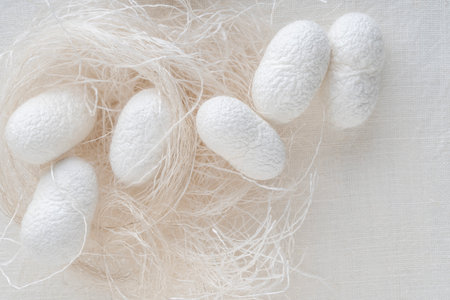 background with silk cocoons commercially bred caterpillar of silkworm moth, spins silk cocoon that is processed to yield silk fiber. textile industry background or surface. natural silk productionの写真素材