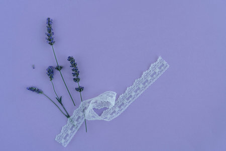 floral background, top view beautiful bunch of lavender flower on purple background with copy space. bunch of flowers with white lace ribbon. floral pattern or surface. lavender on purple backgroundの写真素材