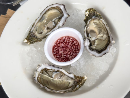 oysters, delicious raw oysters on plate with ice. beautiful raw seafood background or surface. seafood with seashell to eat. traditional French food on plate in France. luxury French food conceptの写真素材