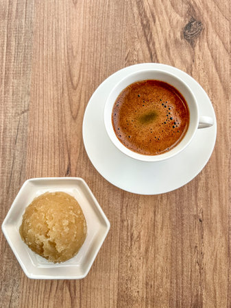 traditional turkish dessert made from semolina and cup of coffee on wooden table. local turkish...
