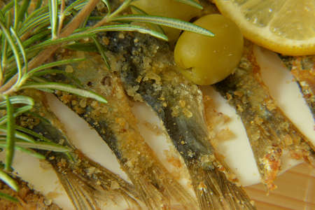 Salted anchovy with lemon, rosemary and olives on plateの写真素材