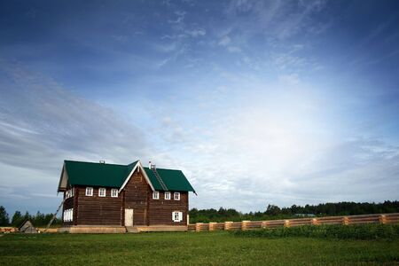 Traditional wooden house at sunny day in the countryside.