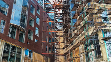 Construction of unfinished buildings, scaffolding, installation of windowsの写真素材
