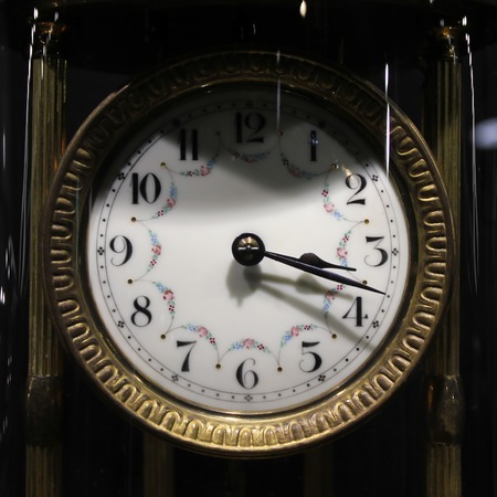 Old vintage antique clock on black background.