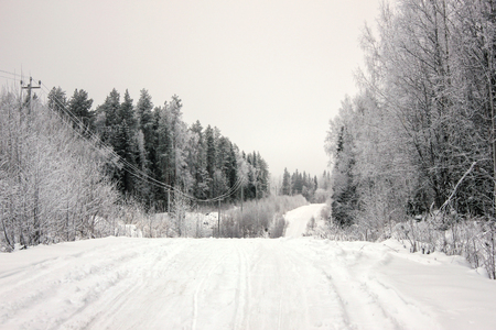 Empty road with huge snow banks on sides on cloudy winter dayの写真素材