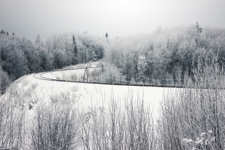Frosrty day. Snow nature winter landscape. View of the winding railway in forestの写真素材