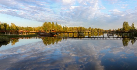 Beautiful summer sunny landscape, lake view with reflection of a blue sky with clouds, forest background.の写真素材