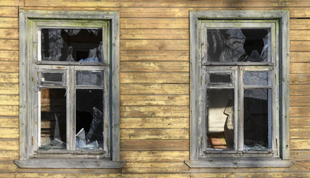 Broken windows in an old wooden ruined house, barrack, ruins.の写真素材