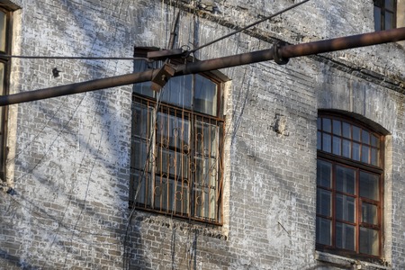 Old worn rounded window with rusty grid in a brick building. Industrial mockup. Vintage effectの写真素材