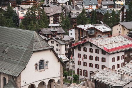 View of the roofs of houses in a Swiss resort. A place preserving authentic architecture. Natural stone roofs, wooden facadesの写真素材