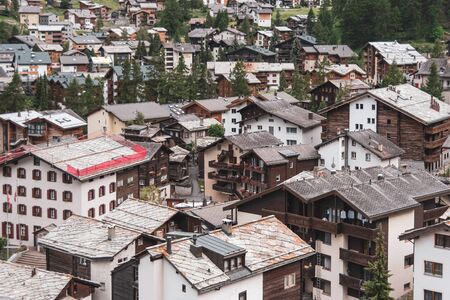 View of the roofs of chalets in a Swiss resort. A place preserving authentic architecture. Natural stone roofs, wooden facadesの写真素材