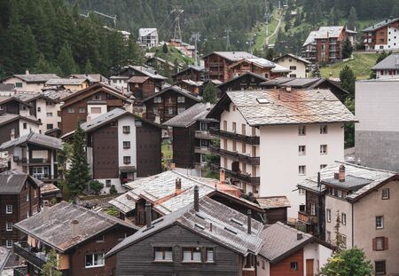 View of the roofs of chalets in a Swiss resort. A place preserving authentic architecture. Natural stone roofs, wooden facades. Zermatt, Switzerland.の写真素材